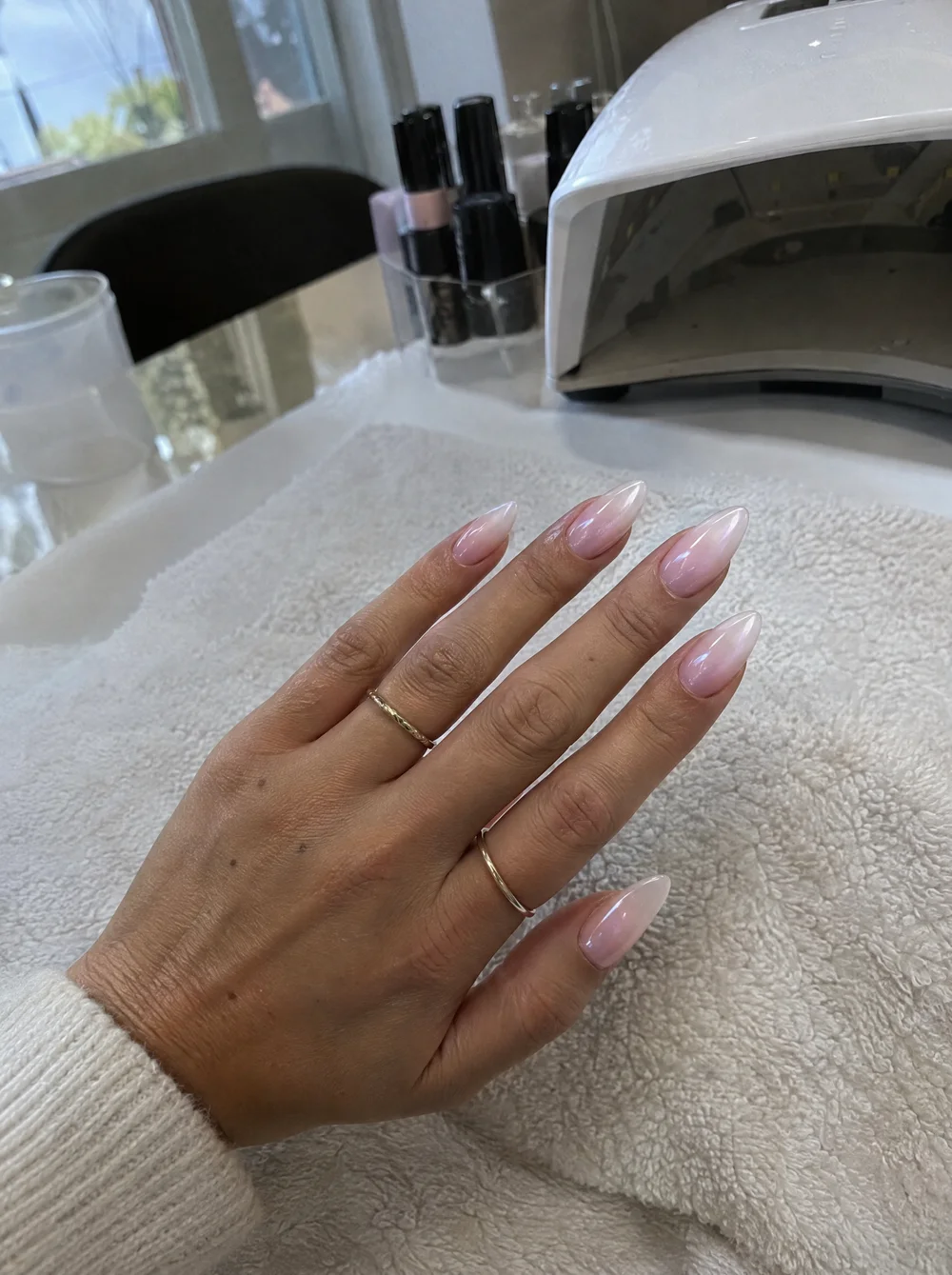 Sfeerbeeld: verse amandelvormige babyboom-nagels met een parelglans op de manicuretafel